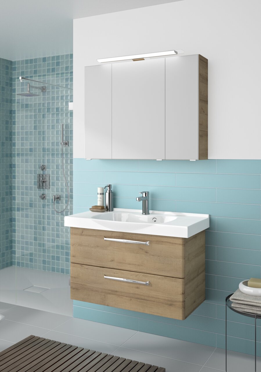 Moderner Badblock mit Holzoptik und weißem Waschbecken, frontal betrachtet, vor einer Wand mit blauen Fliesen.