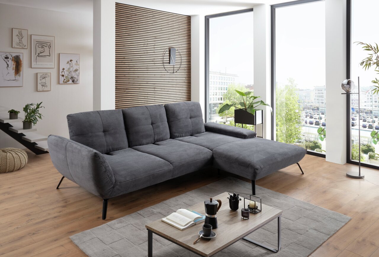 StepOne Ecksofa NEWPORT Graues Ecksofa in modernem Wohnzimmer mit Holzboden und großen Fenstern, seitliche Perspektive