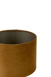 Close-up in bovenaanzicht van een cilindervormige lampenkap met een warme cognacbruine fluwelen bekleding en donkere binnenzijde tegen een witte achtergrond