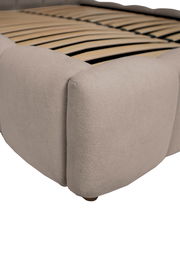 Nahaufnahme eines Polsterbettgestells in Beige mit Holzlattenrost, seitliche Perspektive