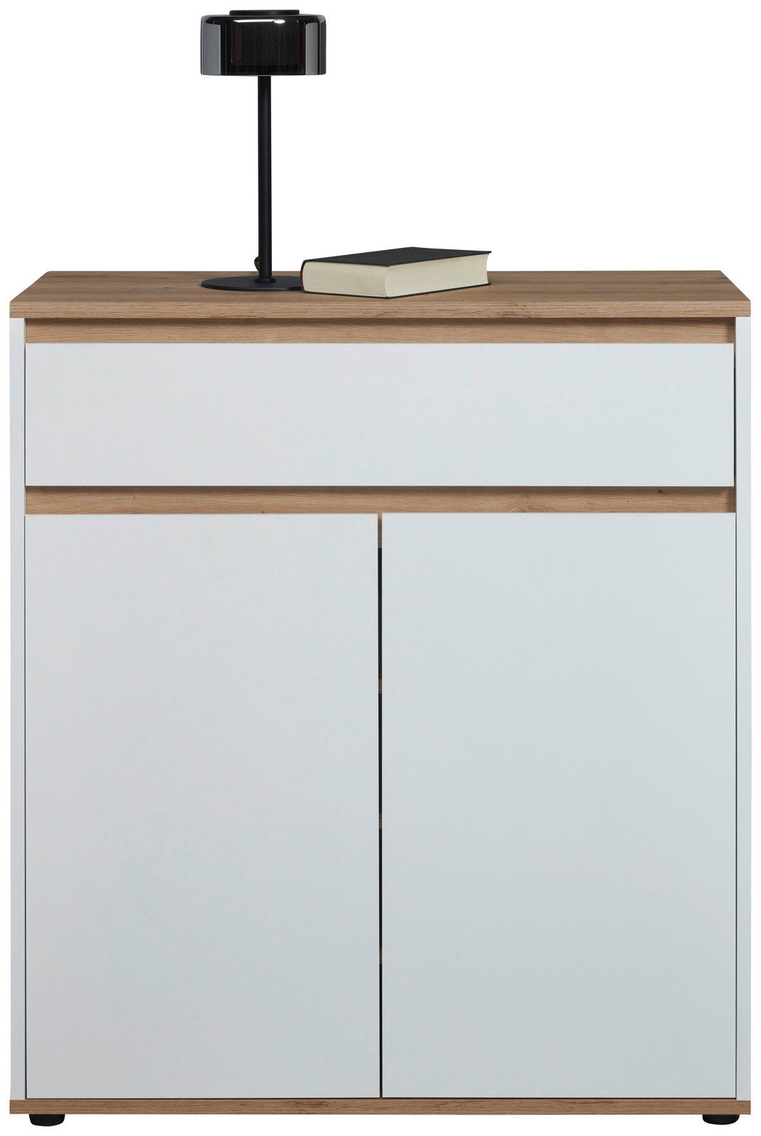 Moderne Kommode in Weiß mit Holzdetails, frontal abgebildet, mit einer schwarzen Lampe und einem Buch auf der Oberseite.