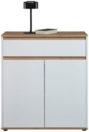 Moderne Kommode in Weiß mit Holzdetails, frontal abgebildet, mit einer schwarzen Lampe und einem Buch auf der Oberseite.