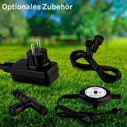 Verschiedene elektrische Zubehörteile auf einer Wiese, darunter ein Netzteil, Kabel und ein T-Stück, aus der Vogelperspektive.