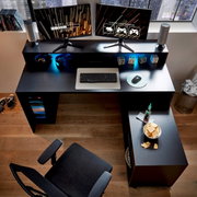 Gaming-Schreibtisch mit zwei Monitoren, Tastatur und Maus aus der Vogelperspektive, umgeben von Kopfhörern, Lautsprechern und Snacks.