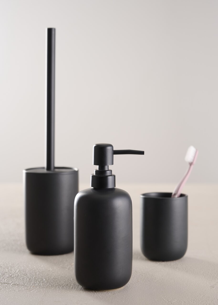 Modernes, dreiteiliges Badset in mattem Schwarz, bestehend aus Seifenspender, Zahnbürstenhalter und Toilettenbürste, aus frontaler Perspektive fotografiert.