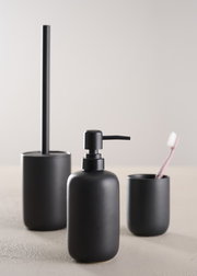 Modernes, dreiteiliges Badset in mattem Schwarz, bestehend aus Seifenspender, Zahnbürstenhalter und Toilettenbürste, aus frontaler Perspektive fotografiert.