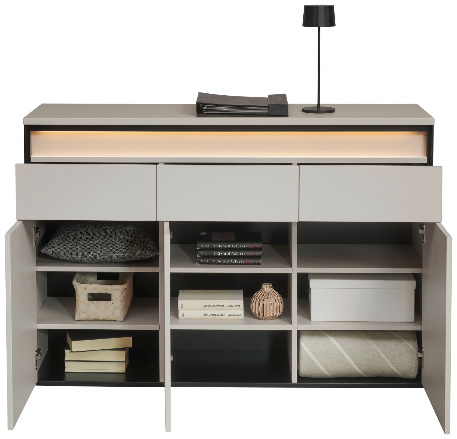 Modernes Sideboard mit offenen Türen, zeigt Regale mit Büchern, Kissen und Dekorationen, aus frontaler Perspektive.