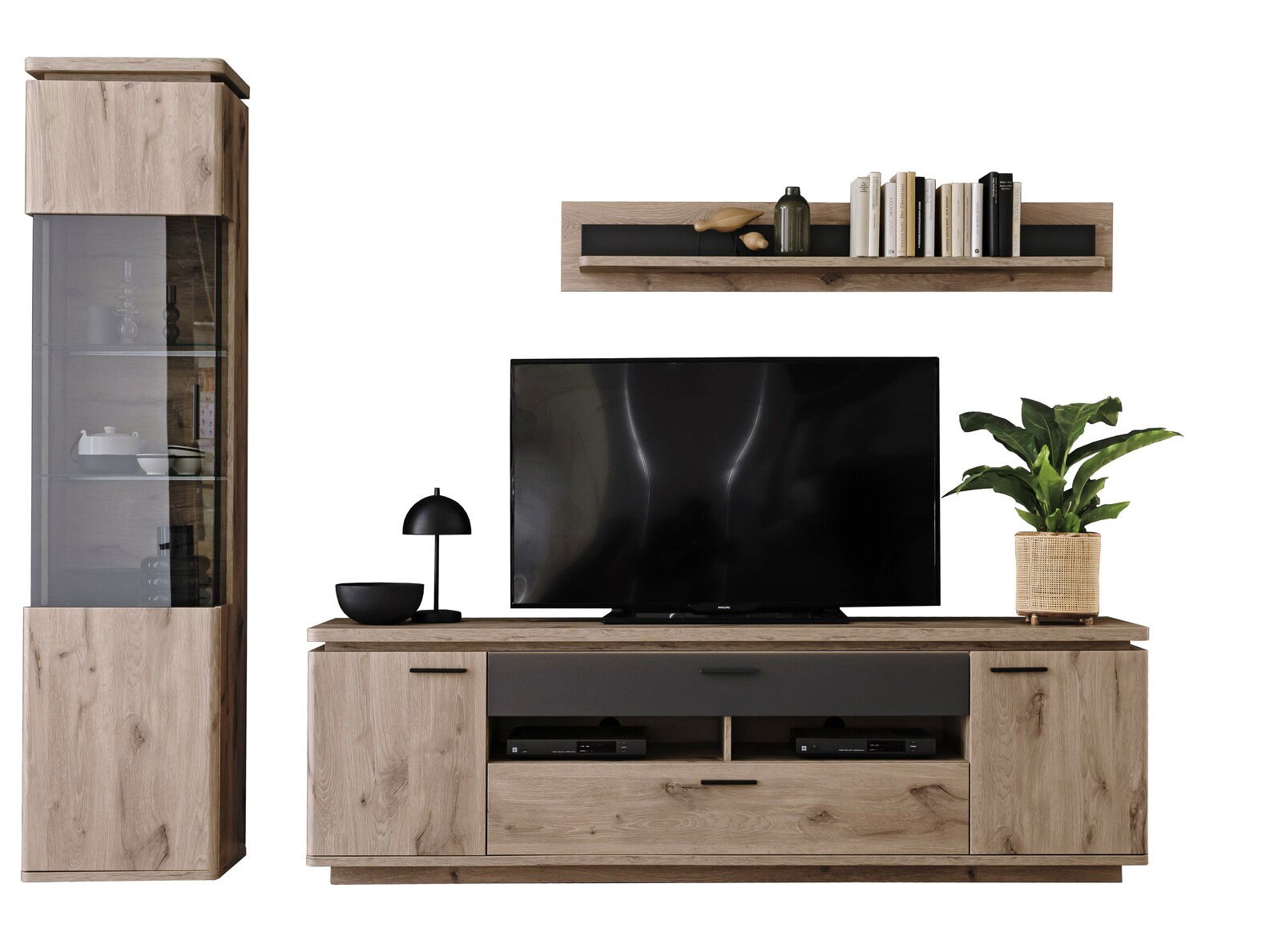 Frontale Ansicht einer modernen Wandkombination aus Holz mit einem TV-Schrank, einem hohen Schrank mit Glastür, einem Regal mit Büchern und Dekoration sowie einem Fernseher und einer Pflanze.