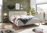 Modernes Polsterbett in einem stilvoll eingerichteten Schlafzimmer, seitliche Perspektive