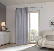 Grauer Fertigvorhang in einem modernen Wohnzimmer, aufgehängt an einer Gardinenstange vor einer Glastür, seitliche Perspektive