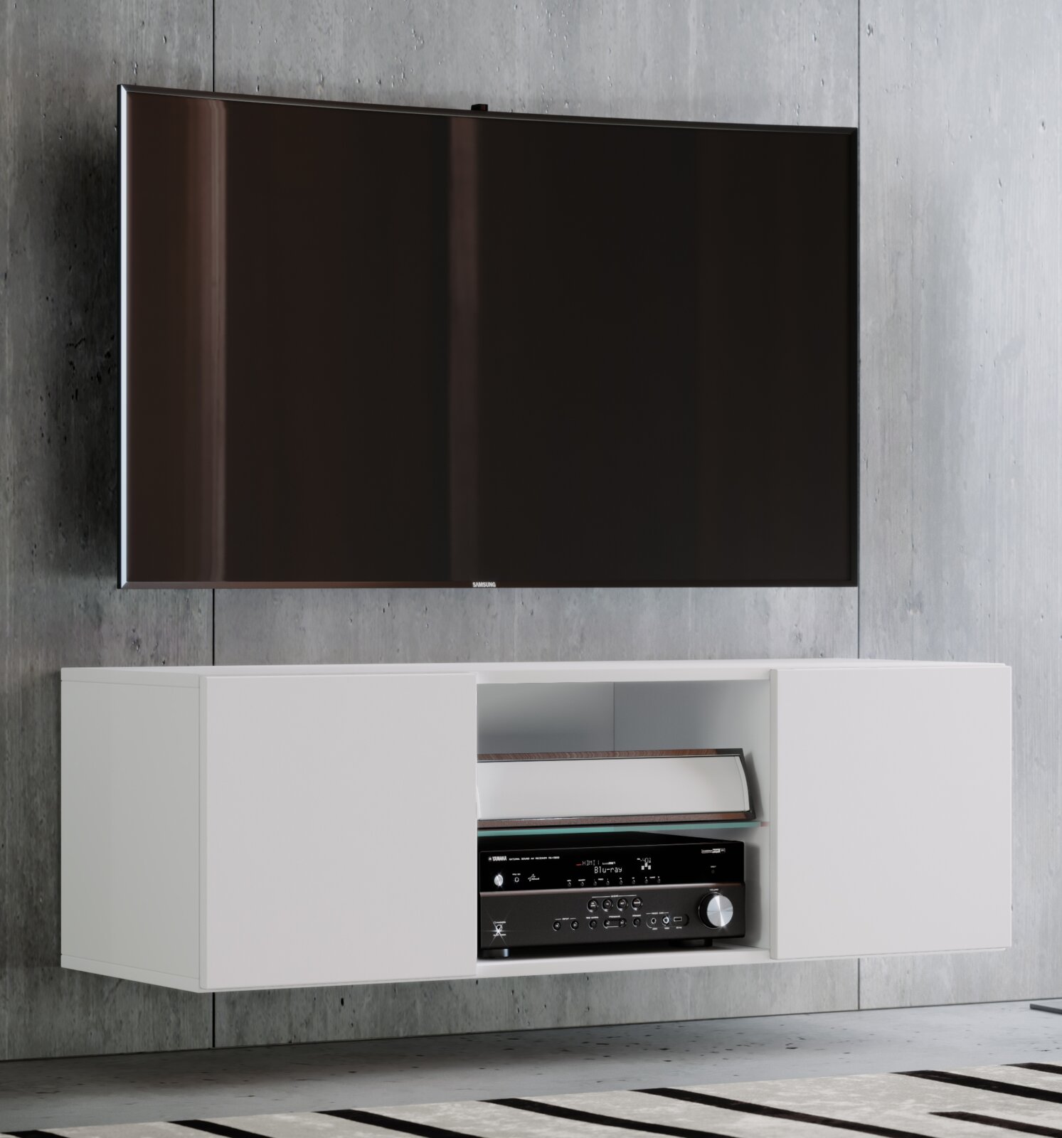 Wandmontiertes weißes TV-Lowboard mit zwei Schiebetüren und offenem Fach mit AV-Receiver darunter, darüber ein flacher Samsung-Fernseher an Betonwand; Frontansicht leicht von links
