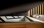 Nahaufnahme eines geöffneten Boxspringbetts mit Stauraum, seitliche Perspektive