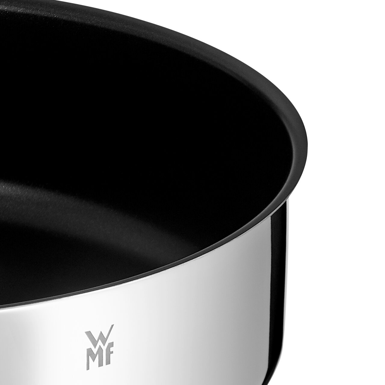 Close-up van een glanzende serveerpan met zwarte binnenbekleding en het WMF-logo.