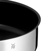 Close-up van een glanzende serveerpan met een zwarte binnenbekleding en het WMF-logo.