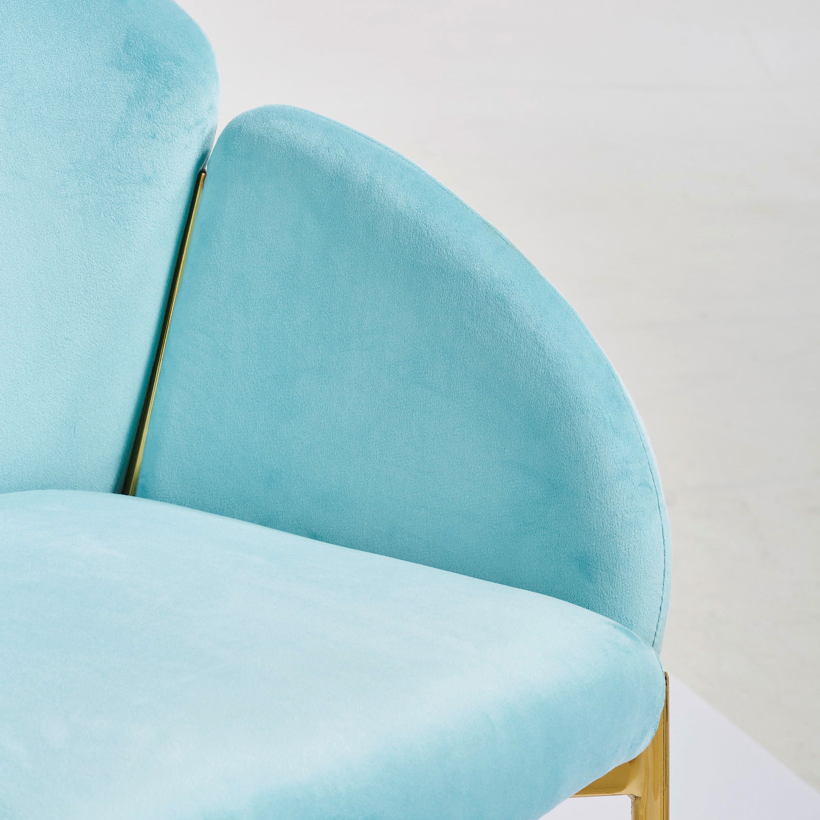 Türkiser Sessel mit goldenen Akzenten, Nahaufnahme von der Seite