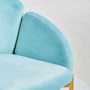 Turquoise fauteuil met gouden accenten, close-up vanaf de zijkant