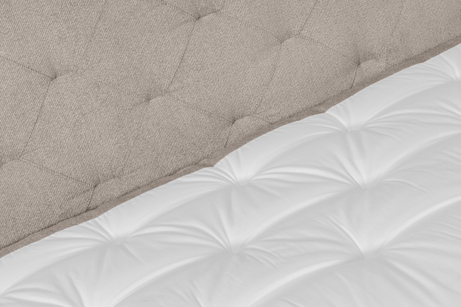 Nahaufnahme eines Boxspringbetts mit gepolstertem Kopfteil in Beige und weißer Matratze, seitliche Perspektive