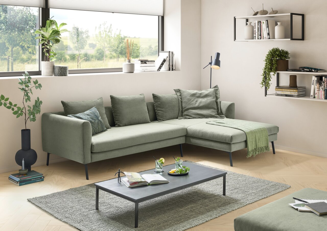 Grünes Ecksofa in modernem Wohnzimmer, seitliche Perspektive