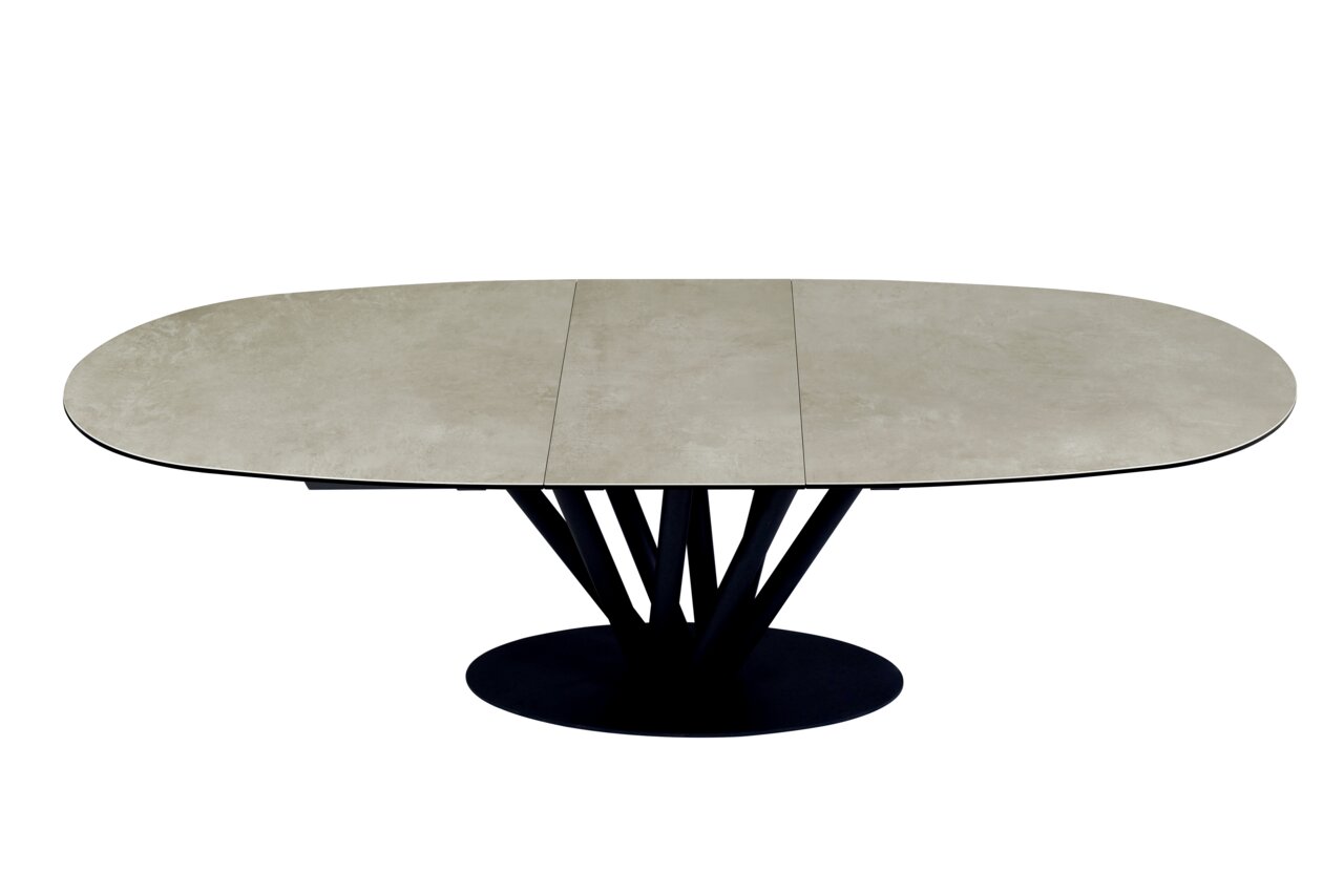 Moderne eettafel met een ovaal, uitschuifbaar tafelblad in steenlook en een zwart, sculpturaal onderstel, gezien van bovenaf.