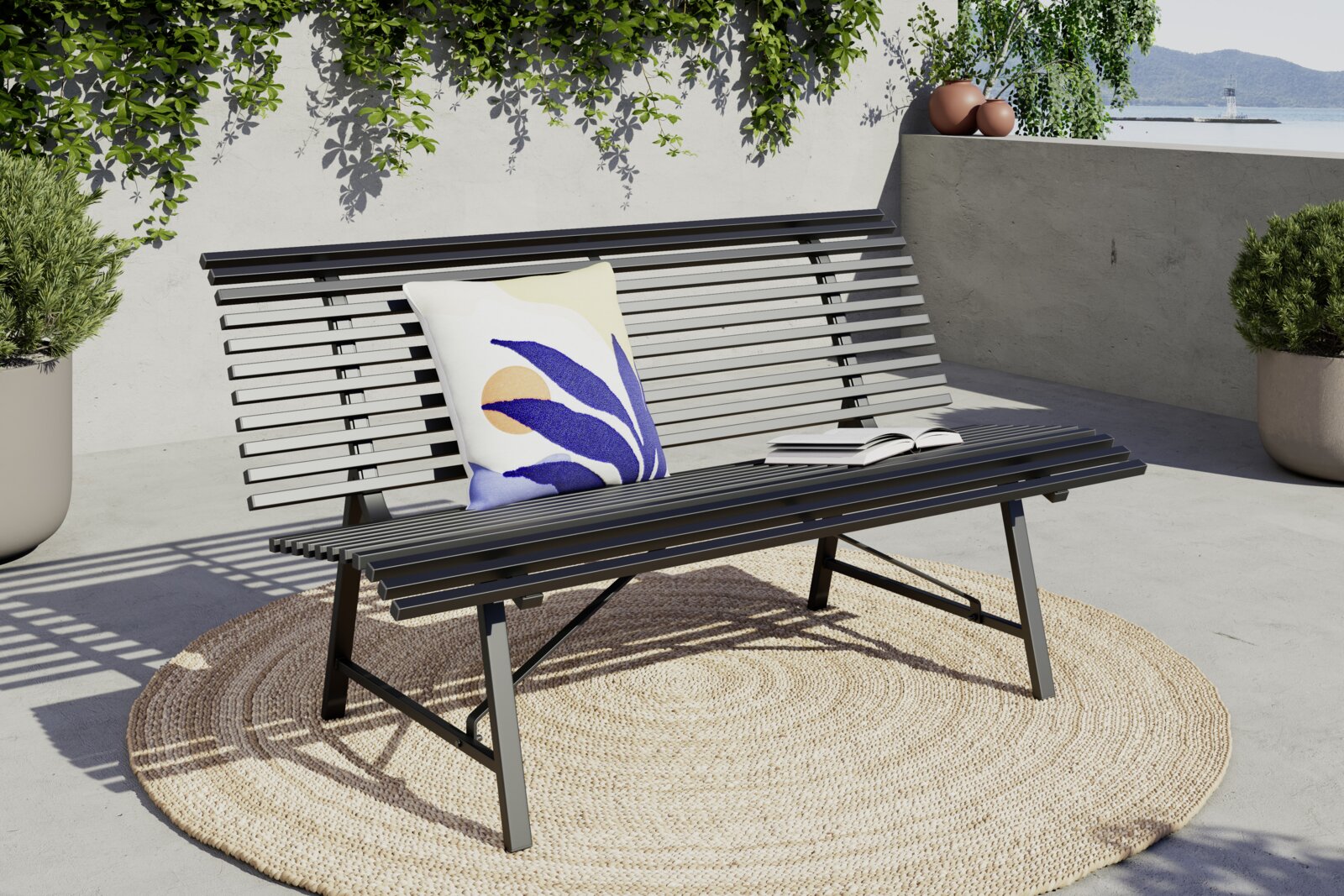 Moderne Gartenbank aus Metall mit Kissen und Buch, seitliche Perspektive, auf einer Terrasse mit Pflanzen im Hintergrund.