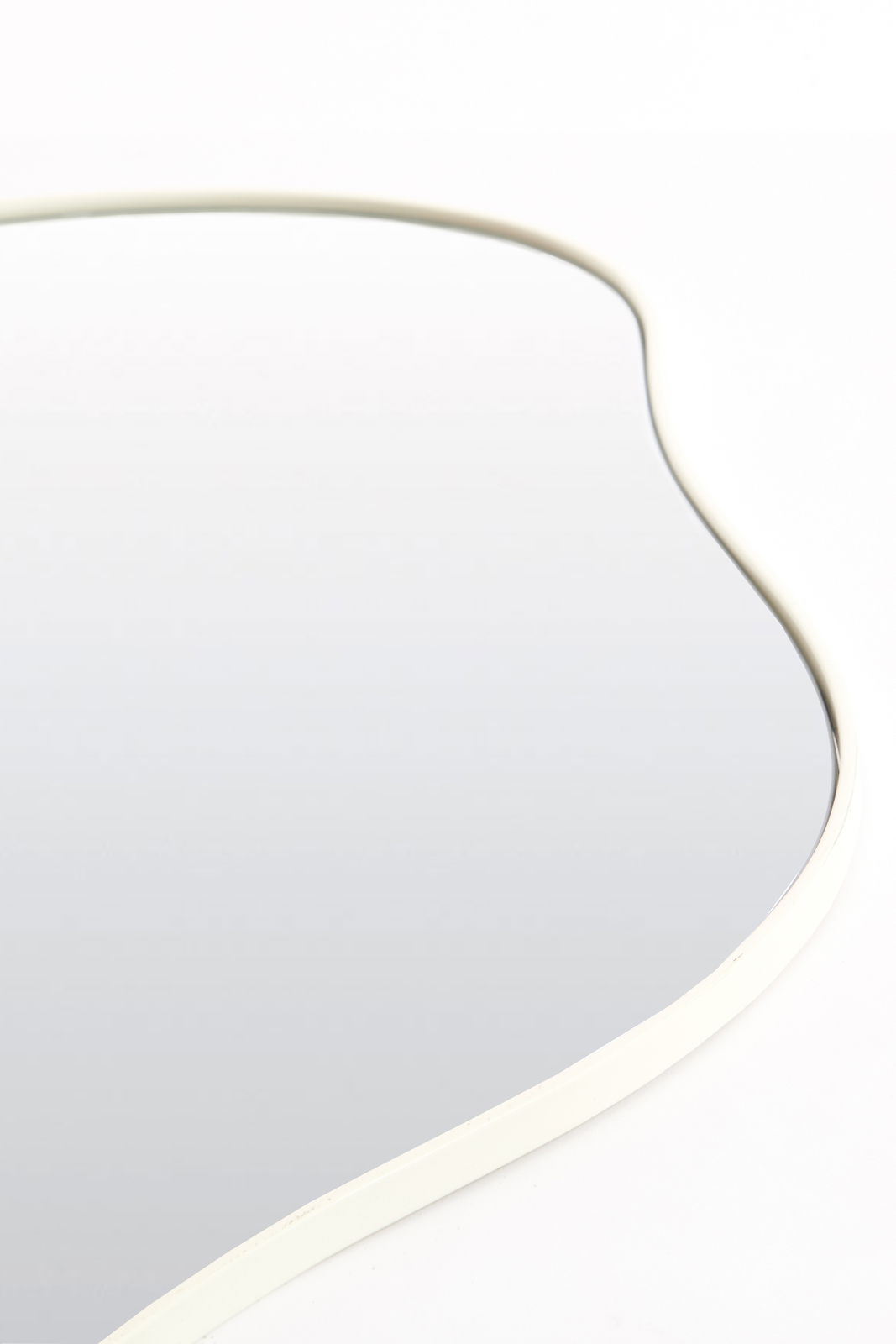 Light&Living Spiegel AZULA Nahaufnahme eines geschwungenen Spiegels mit weißem Rahmen, aus der Seitenperspektive fotografiert.