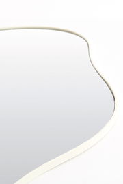 Nahaufnahme eines geschwungenen Spiegels mit weißem Rahmen, aus der Seitenperspektive fotografiert.