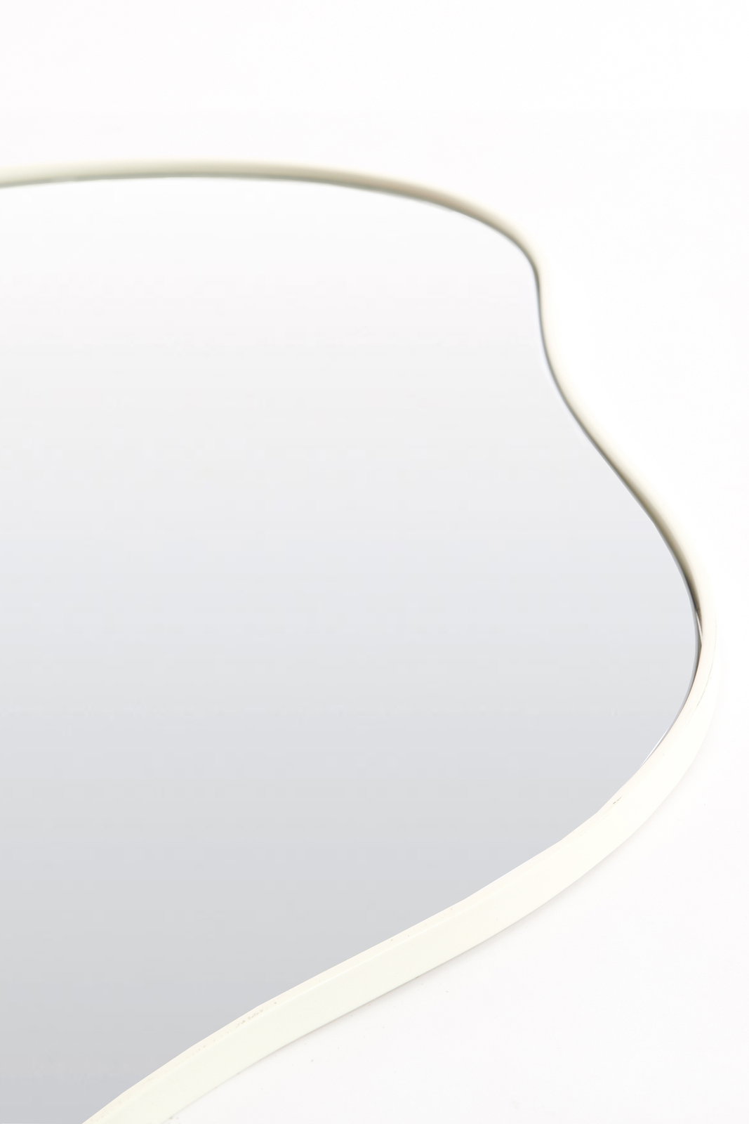 Light&Living Spiegel AZULA Nahaufnahme eines geschwungenen Spiegels mit weißem Rahmen, aus der Seitenperspektive fotografiert.