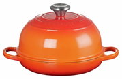 Rode broodbraadpan van Le Creuset, zijaanzicht, met twee handgrepen en een rond deksel met metalen knop.