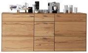 Vooraanzicht van een modern dressoir van licht hout met meerdere lades en deuren, versierd met serviesgoed en een koffiezetapparaat.
