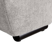 Nahaufnahme der unteren Ecke eines Big-Sofas mit grauem Stoffbezug und schwarzen Füßen.