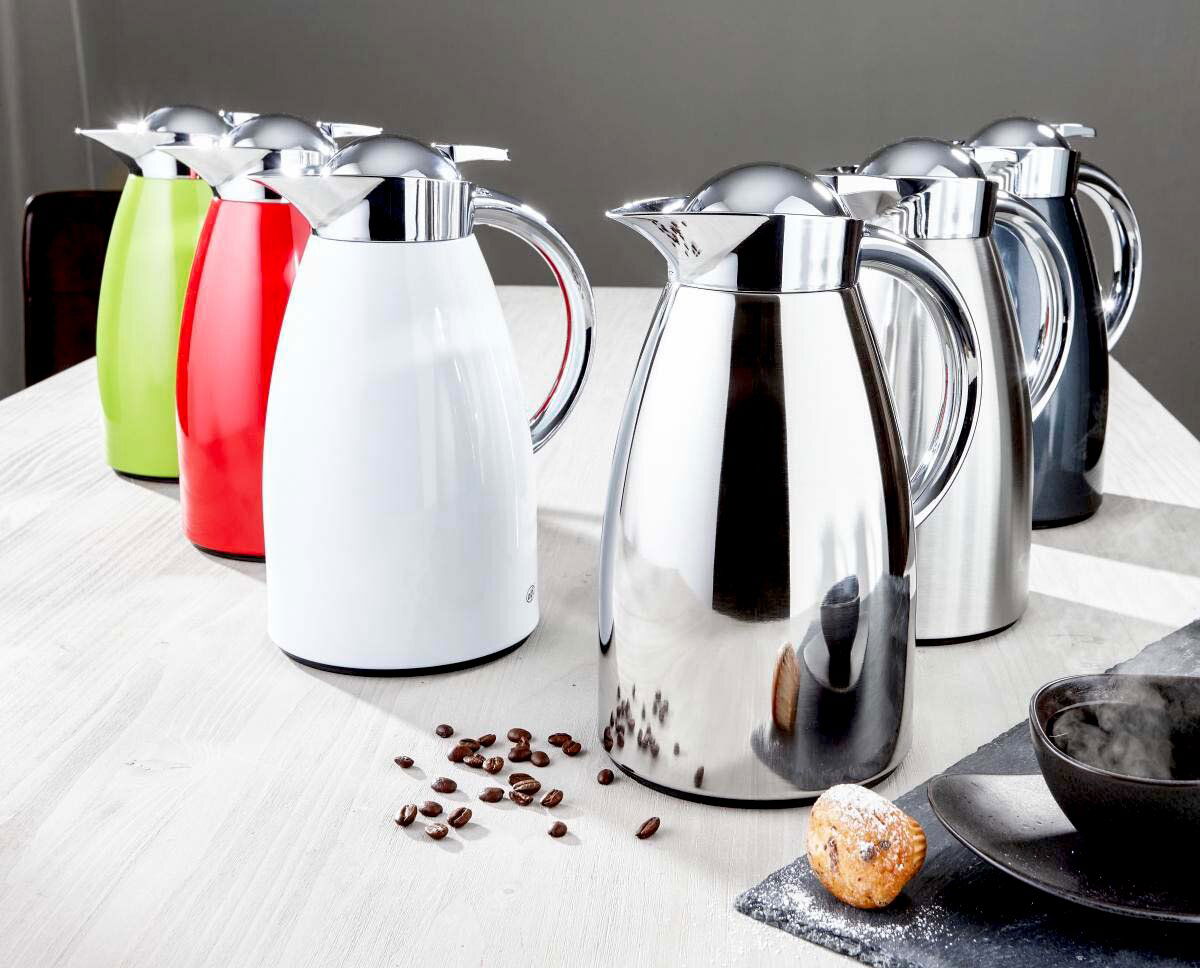 Mehrere Isolierkannen Signo aus Edelstahl in verschiedenen Farben auf einem Tisch, seitliche Perspektive.