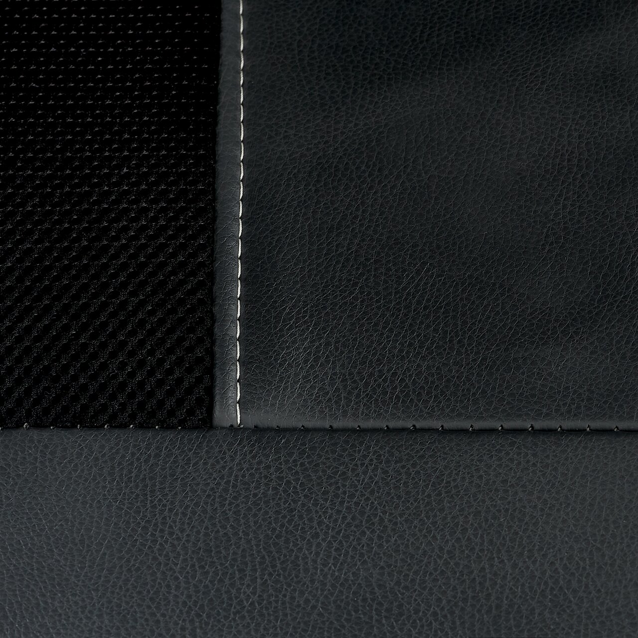 Nahaufnahme eines Chefsessels mit schwarzem Netzstoff und glattem Leder, Naht sichtbar