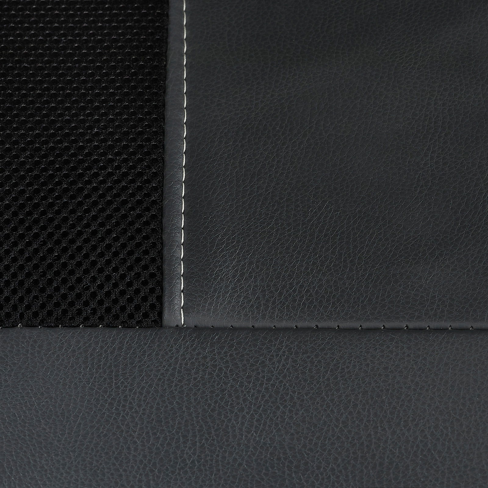 Nahaufnahme eines Chefsessels mit schwarzem Netzstoff und glattem Leder, Naht sichtbar