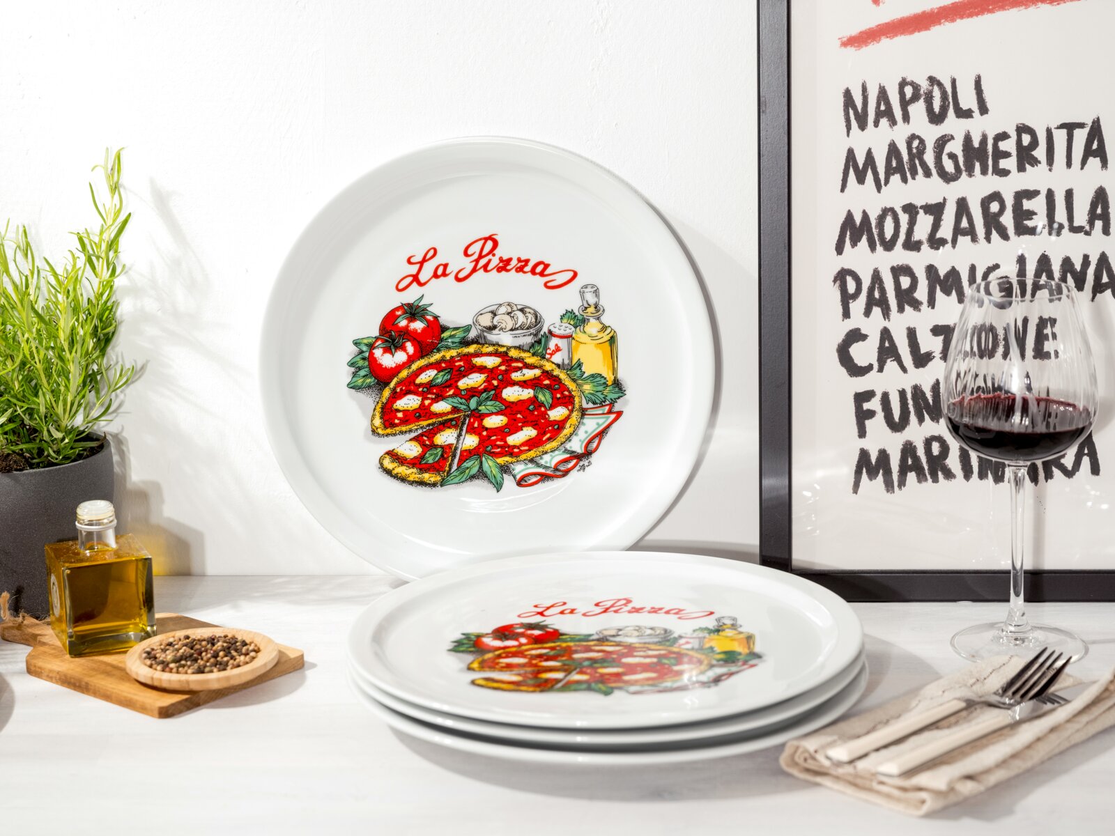 creaTable Pizzateller 4-tlg MILANO Weiße Pizza-Teller mit farbigem „La Pizza“-Motiv (Pizza, Tomaten, Basilikum, Ölflasche) auf Tisch arrangiert, ein Teller stehend im Hintergrund und ein Stapel Teller im Vordergrund, Perspektive: frontale Ansicht mit leichtem Blick von oben.