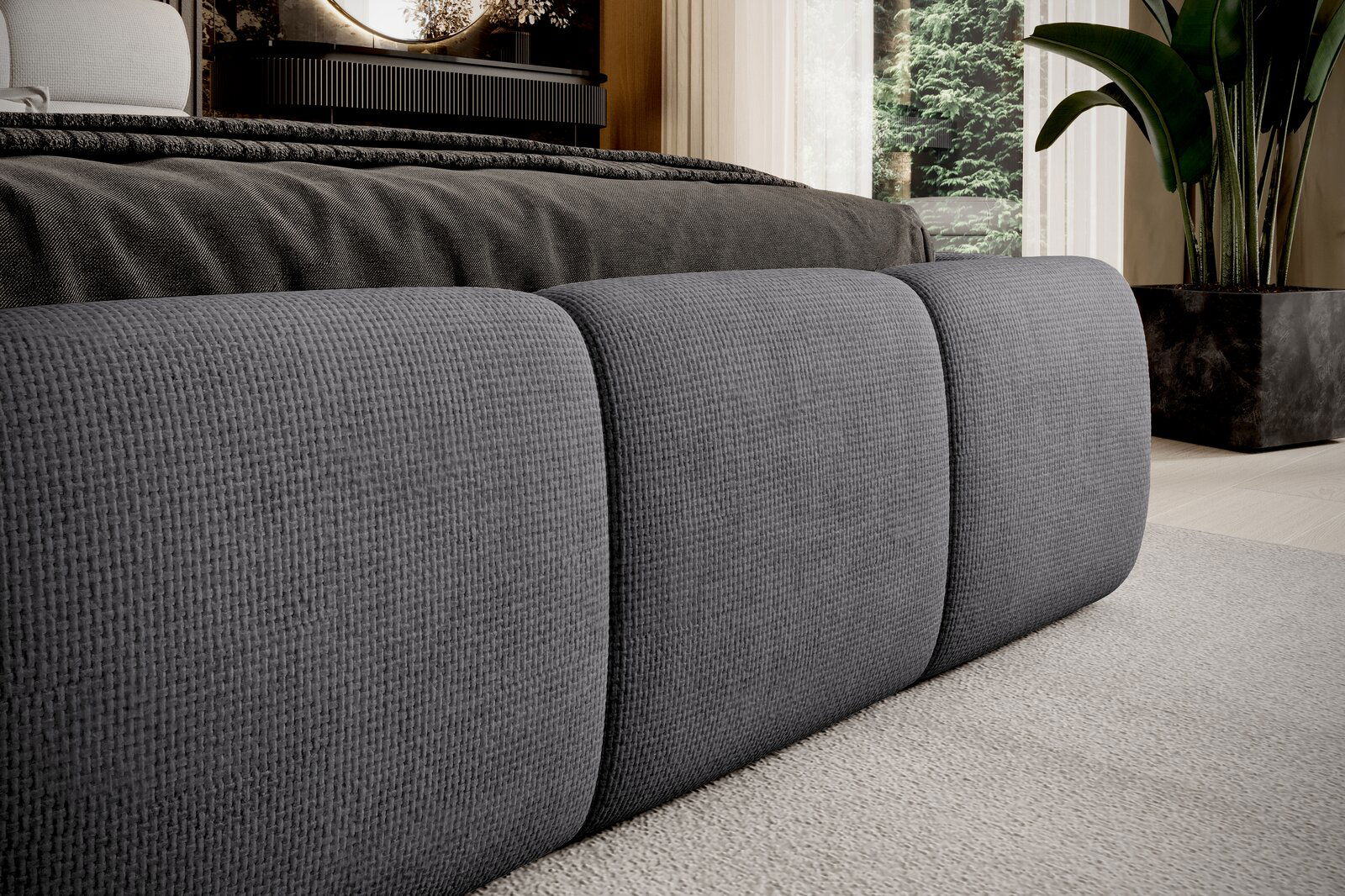 Nahaufnahme eines grauen Polsterbettgestells mit strukturierter Oberfläche, seitliche Perspektive.