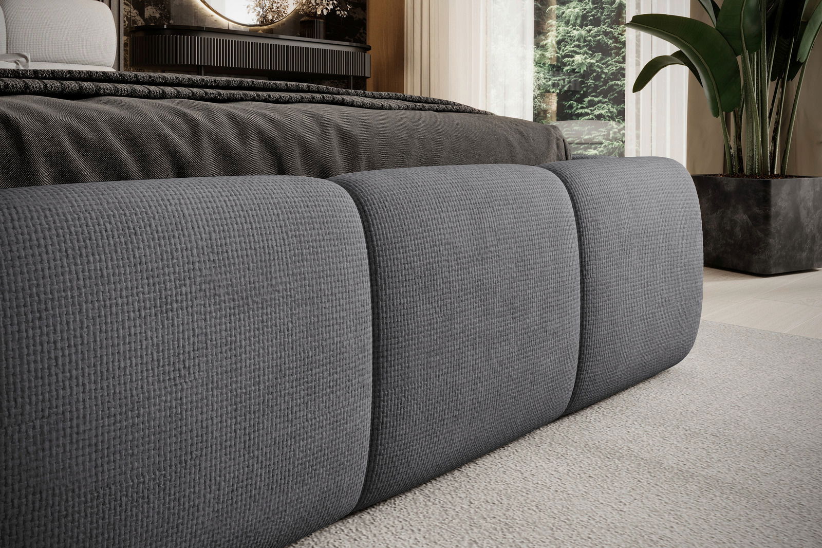 Nahaufnahme eines grauen Polsterbettgestells mit strukturierter Oberfläche, seitliche Perspektive.