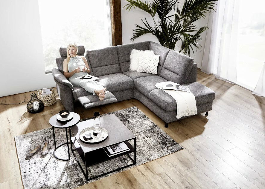 Moderner grauer Couchtisch in einem stilvollen Wohnzimmer, fotografiert aus der Vogelperspektive.