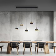 Moderne LED-Pendelleuchte mit fünf hängenden Lampen über einem Esstisch, seitliche Perspektive.