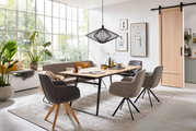 Esszimmer mit modernem Esstisch aus Holz und stilvollen Sesseln in einem hellen Raum mit großen Fenstern, seitliche Perspektive