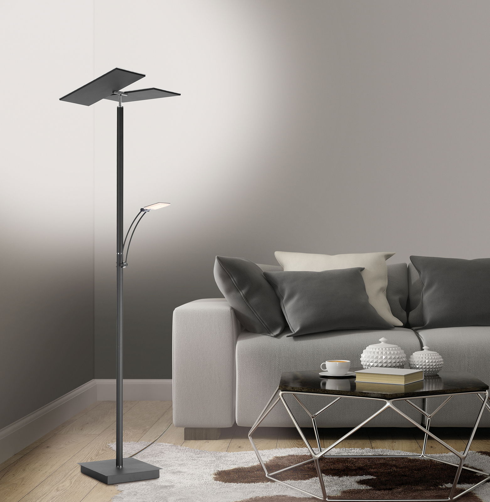 Moderne LED-Stehleuchte in einem Wohnzimmer, seitliche Perspektive, neben einem grauen Sofa und einem Couchtisch.