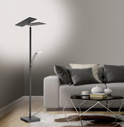 Moderne LED-Stehleuchte in einem Wohnzimmer, seitliche Perspektive, neben einem grauen Sofa und einem Couchtisch.