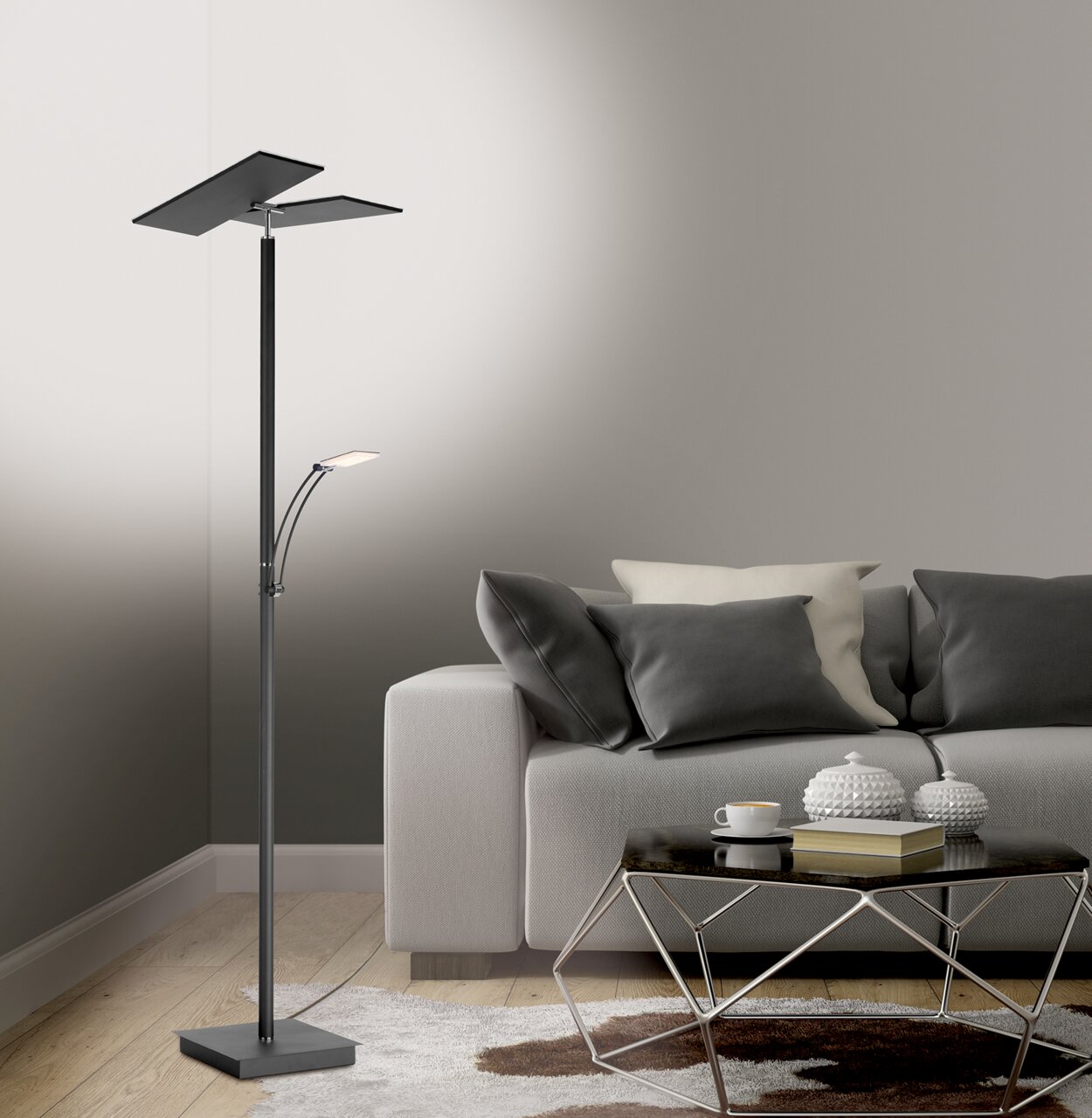 Moderne LED-Stehleuchte in einem Wohnzimmer, seitliche Perspektive, neben einem grauen Sofa und einem Couchtisch.