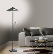 Moderne LED-Stehleuchte in einem Wohnzimmer, seitliche Perspektive, neben einem grauen Sofa und einem Couchtisch.