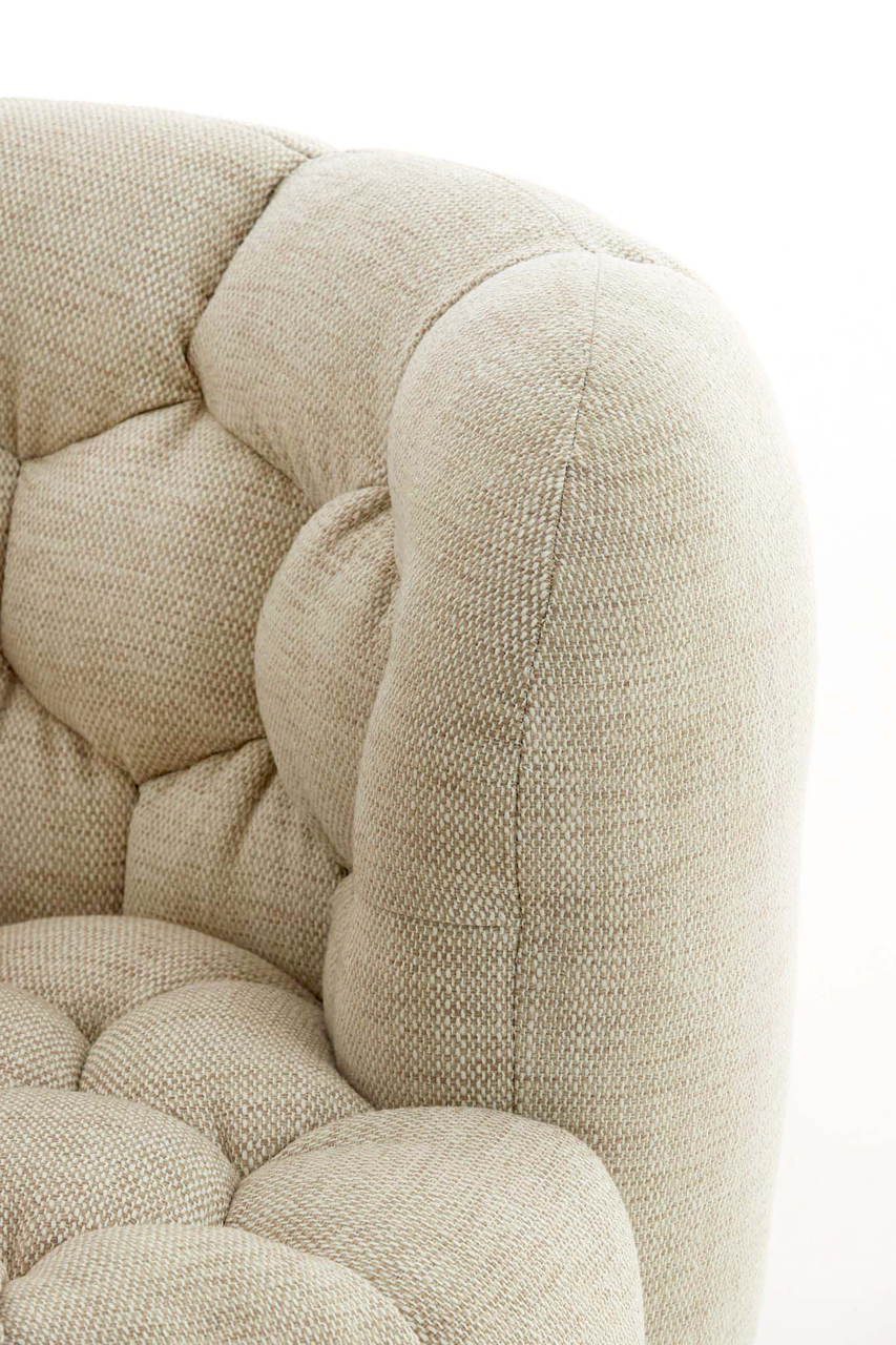 Detailansicht eines beigen Sessels mit gepolstertem Stoff und Knopfheftung.
