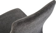 Detailaufnahme eines grauen, gepolsterten Stoffstuhls mit geschwungener Rückenlehne, schräg von hinten/seitlich fotografiert