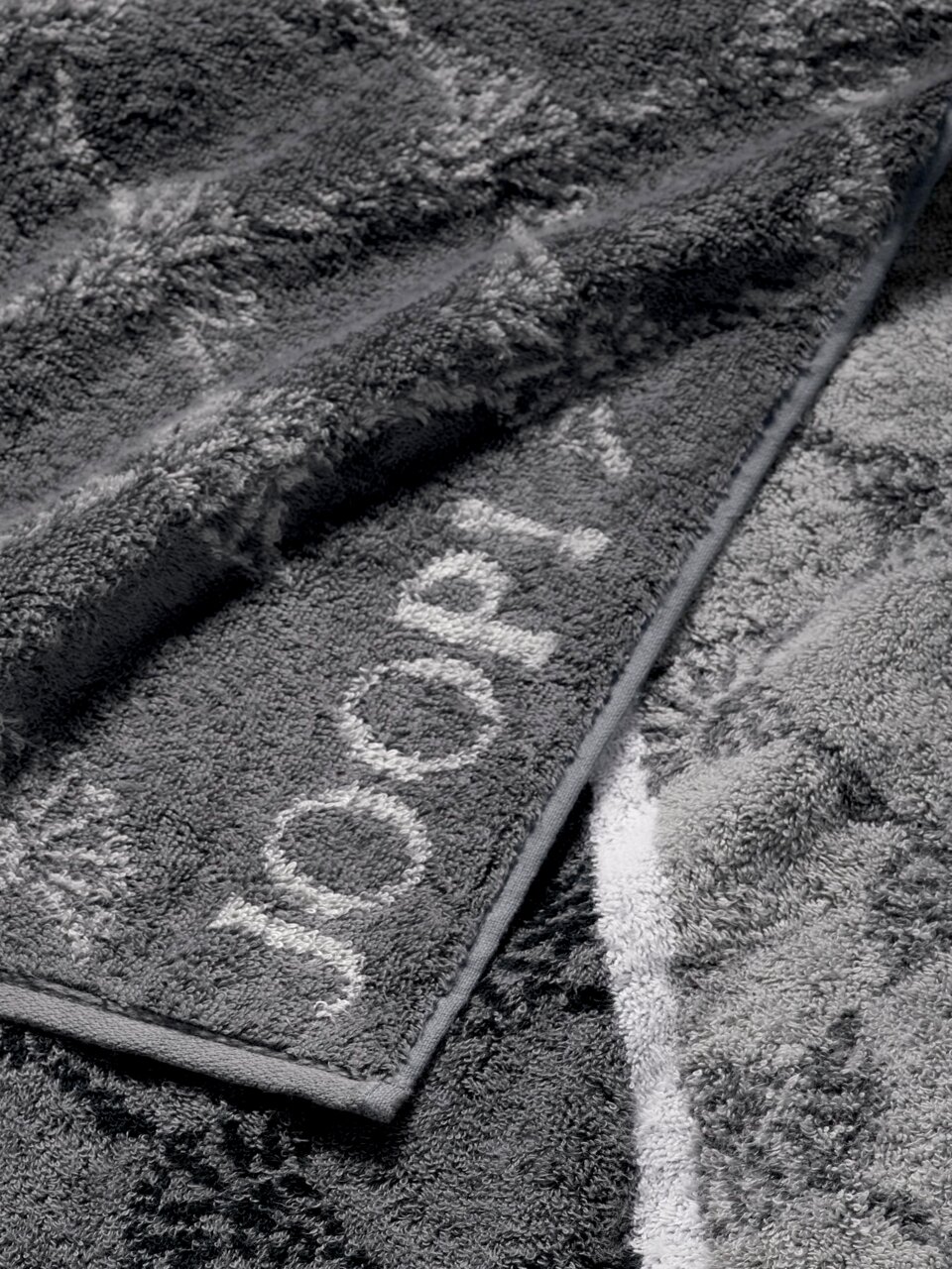 JOOP! Douchehanddoek SIGNATURE Grijze douchehanddoek met ingeweven patroon en merklogo, close-up
