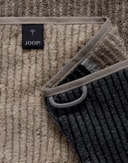 Nahaufnahme eines gestreiften Duschtuchs in verschiedenen Grautönen mit einem Joop-Label.