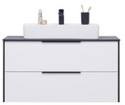 Vooraanzicht van een moderne wastafelcombinatie met een witte wastafel, twee lades en zwarte accenten.