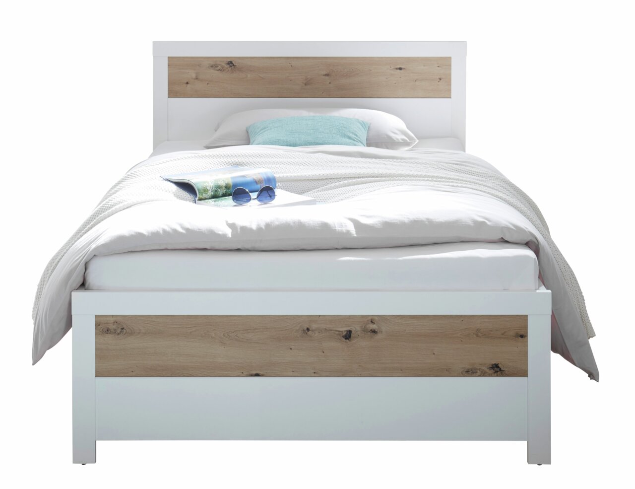 Modernes Bett mit weißem Rahmen und Holzakzenten, frontal fotografiert. Auf dem Bett liegt eine Zeitschrift und eine Sonnenbrille.