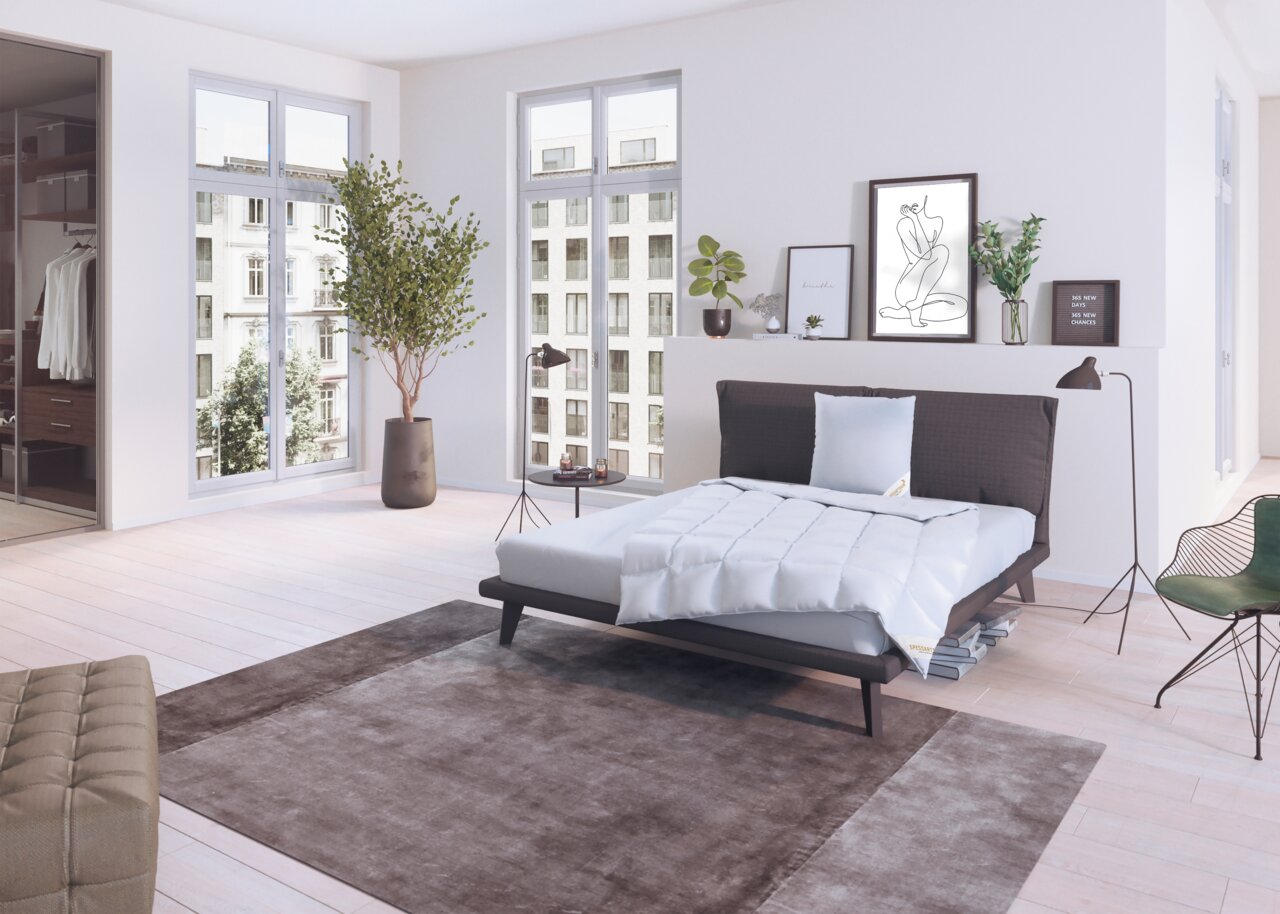 Spessarttraum Bed voor het hele jaar door 135 x 200 cm CLASSIC Moderne slaapkamer met een stijlvol bed, ingericht met een wit Spessarttraum CLASSIC-bed voor alle seizoenen en een driekamerkussen. Het perspectief toont het bed vanaf de zijkant in een lichte, elegante ruimte met grote ramen en een minimalistische inric